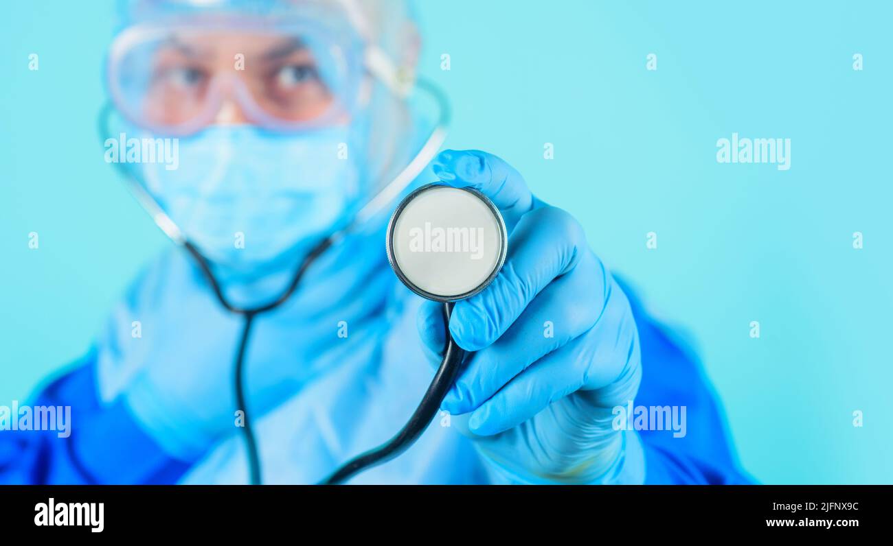 Doctor in protective suit and medical mask with stethoscope. Selective focus. Healthcare. Medicine. Stock Photo
