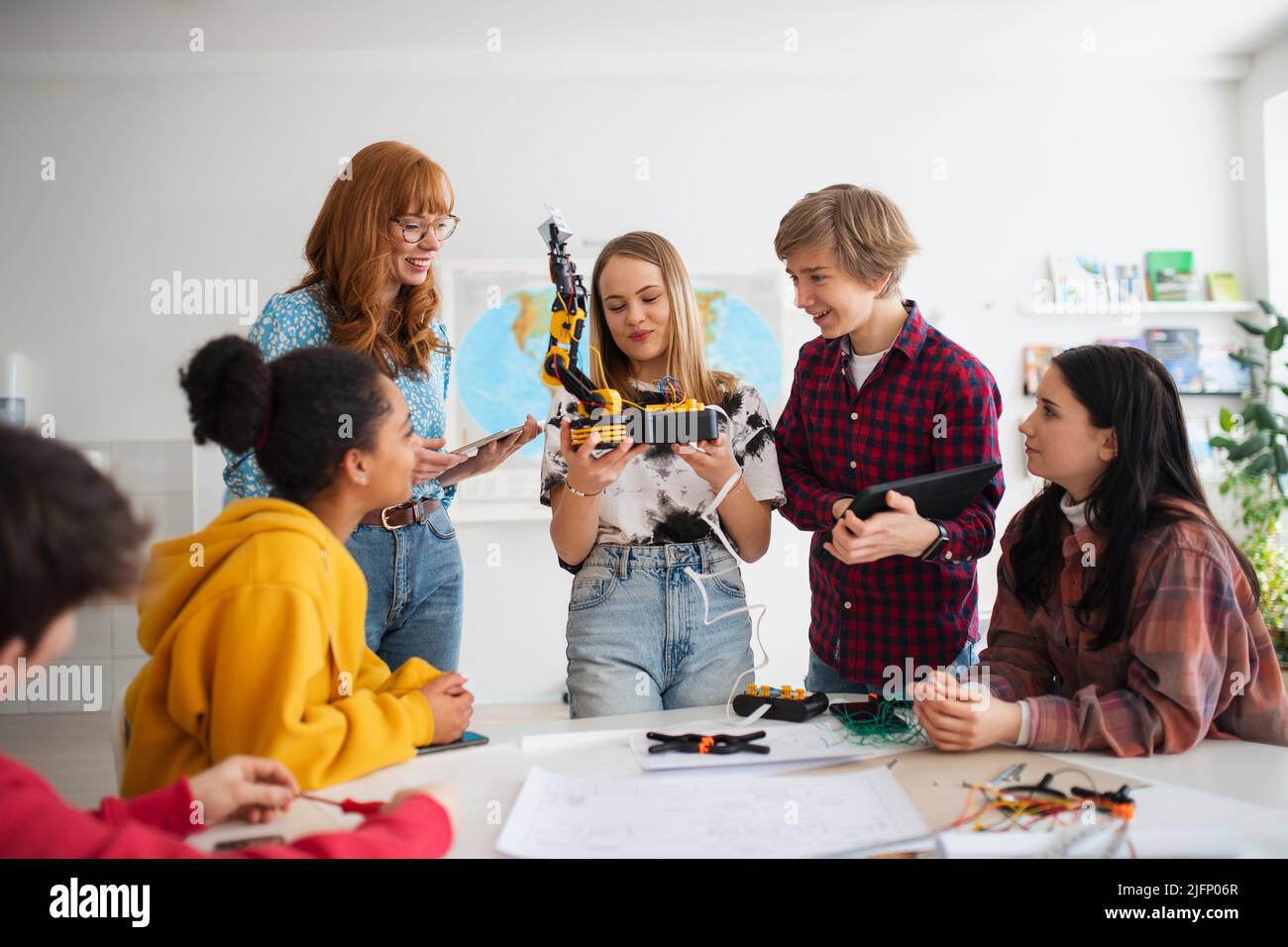 Group of students building and programming electric toys and robots at ...