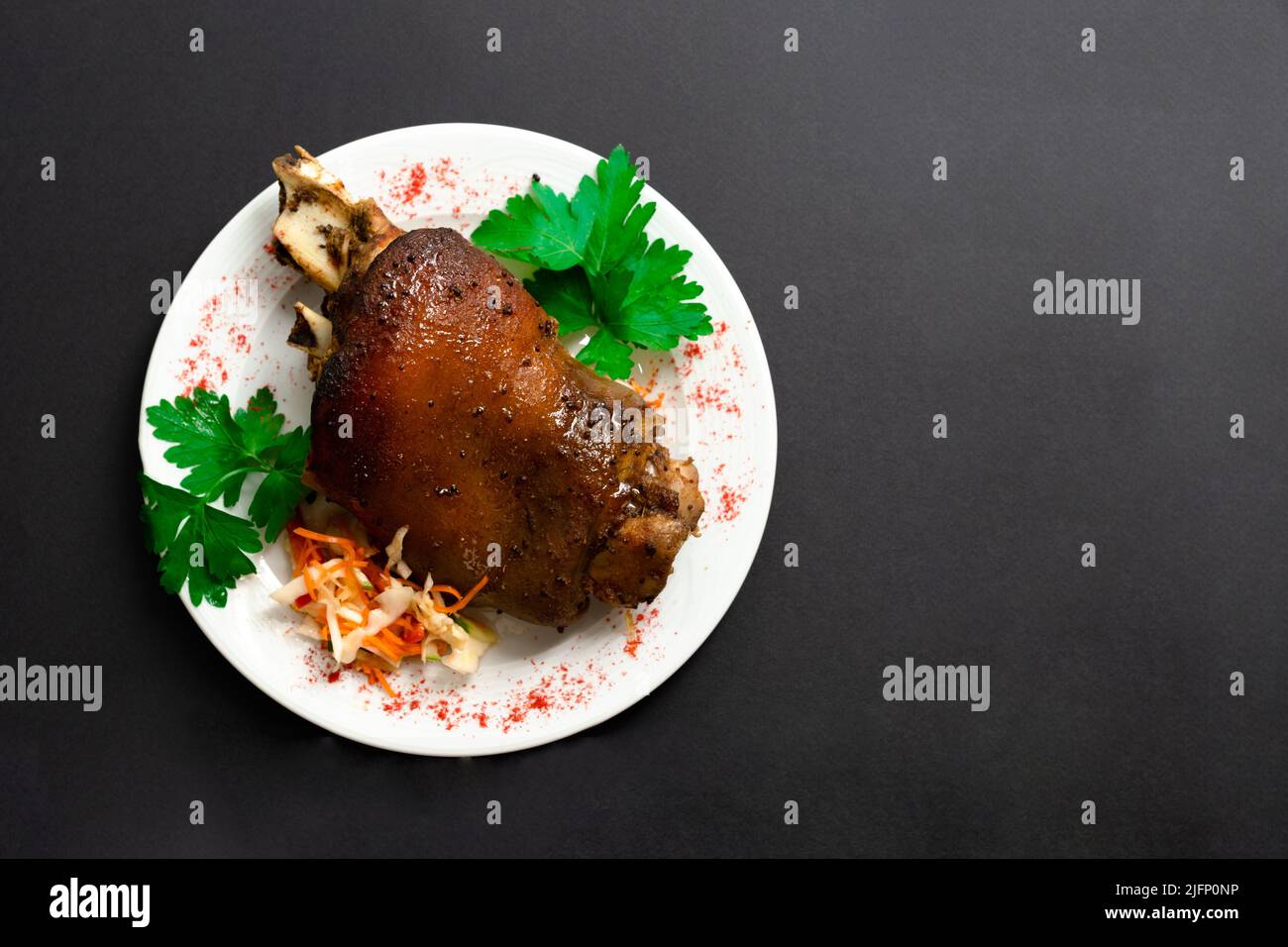 Roasted pork knuckle. Ham and bacon are popular foods in the west. Smoked ham hock with herbs and spices. Black isolated .German Haxe or Schweinshaxe. Stock Photo
