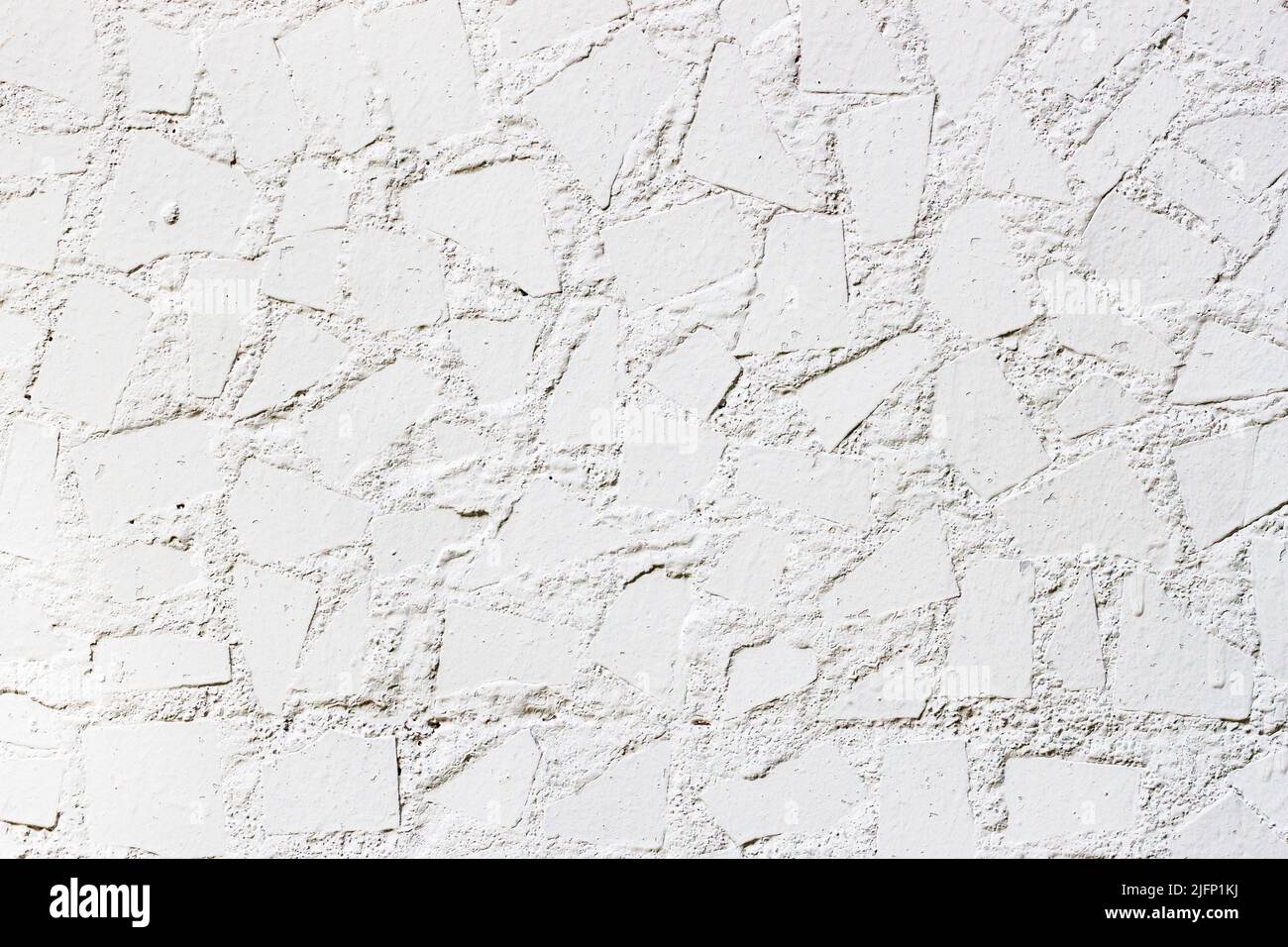 White decorative wall with tiles pieces close-up. Abstract background Stock Photo