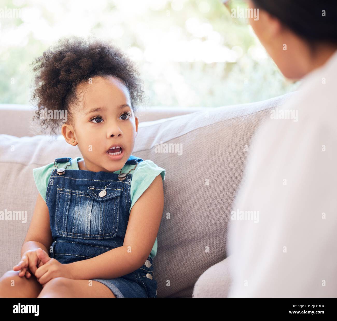 Mom said I should tell you anything you want to know. Shot of a psychiatrist talking to a little girl during a consultation. Stock Photo