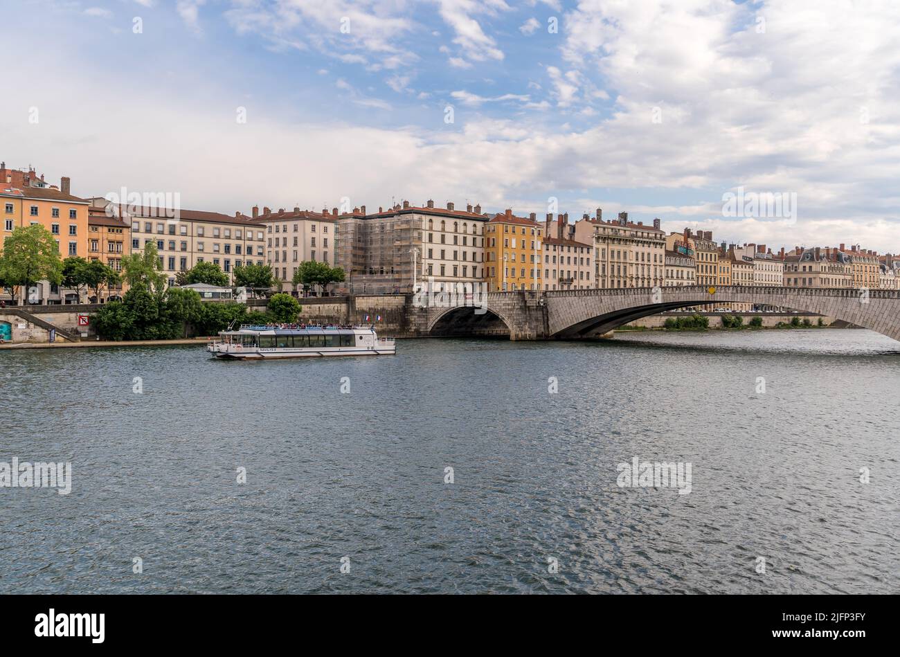 Riverside view of Lyon with colorful apartment buildings , river boat