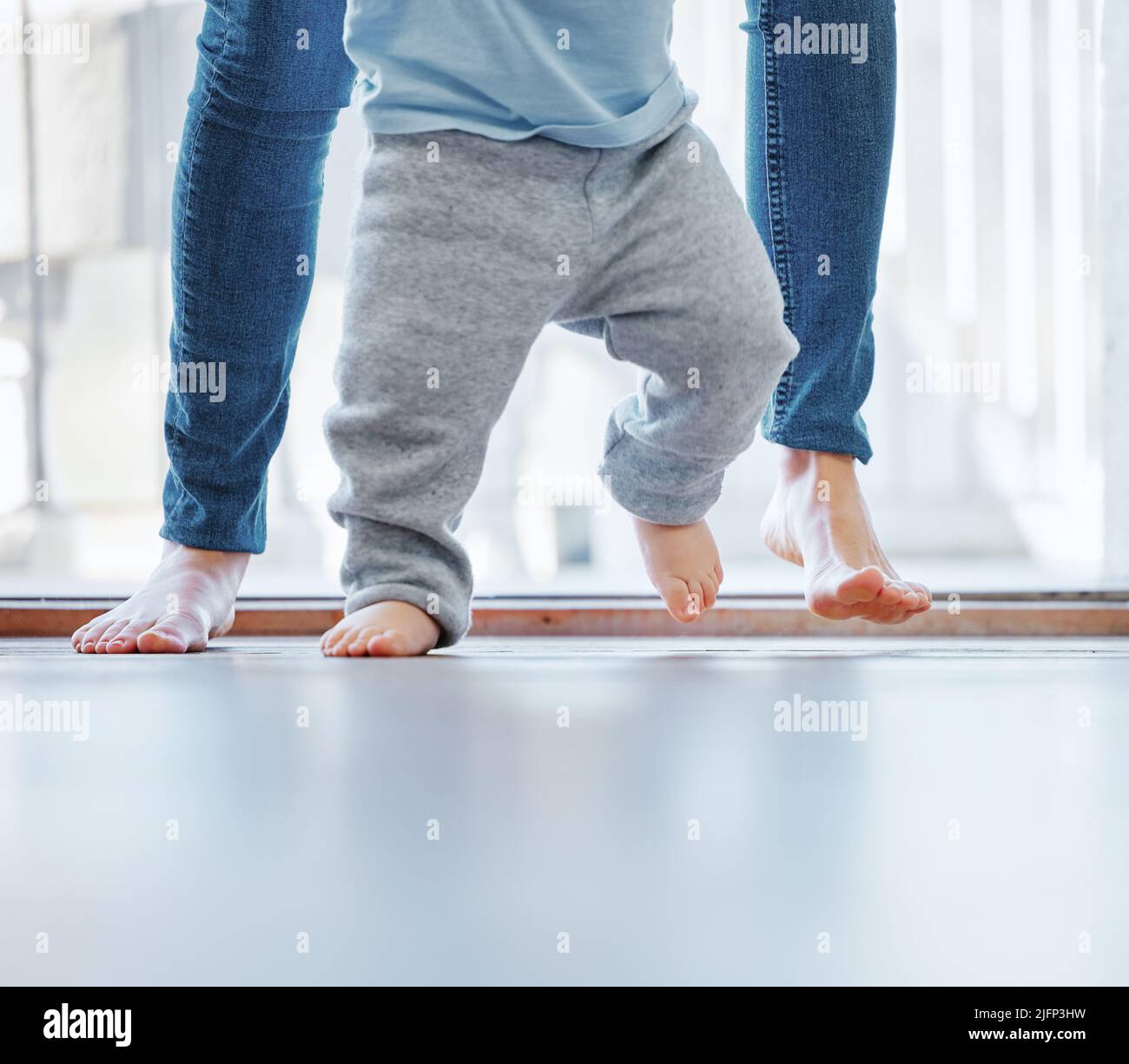 Learning to walk with mommy. Cropped shot of an unrecognizable little boy learning to walk with the help of his mother at home. Stock Photo