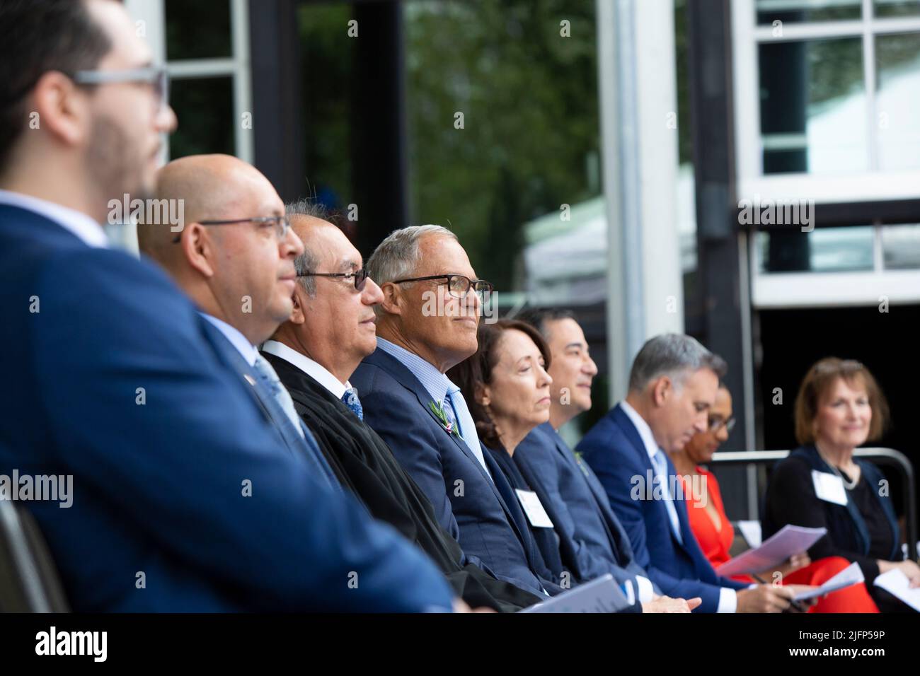 Seattle, Washington, USA. 4th July, 2022. Dignitaries including Washington Governor Jay Inslee (center), congresswoman Suzan DelBene (center right) and Washington Secretary of State Steve Hobbs (right) prepare for a naturalization ceremony at Fisher Pavilion. The U.S. Citizenship and Immigration Services and U.S. District Court for the Western District of Washington partnered with Seattle Center to host the annual ceremony welcoming 300. Credit: Paul Christian Gordon/Alamy Live News Stock Photo