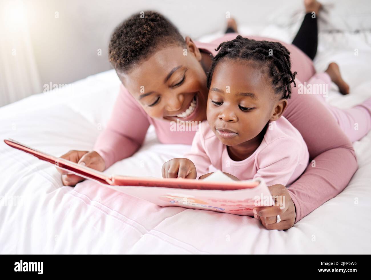 Take your time, try your best. Shot of a beautiful young woman bonding with her daughter in bed at home. Stock Photo