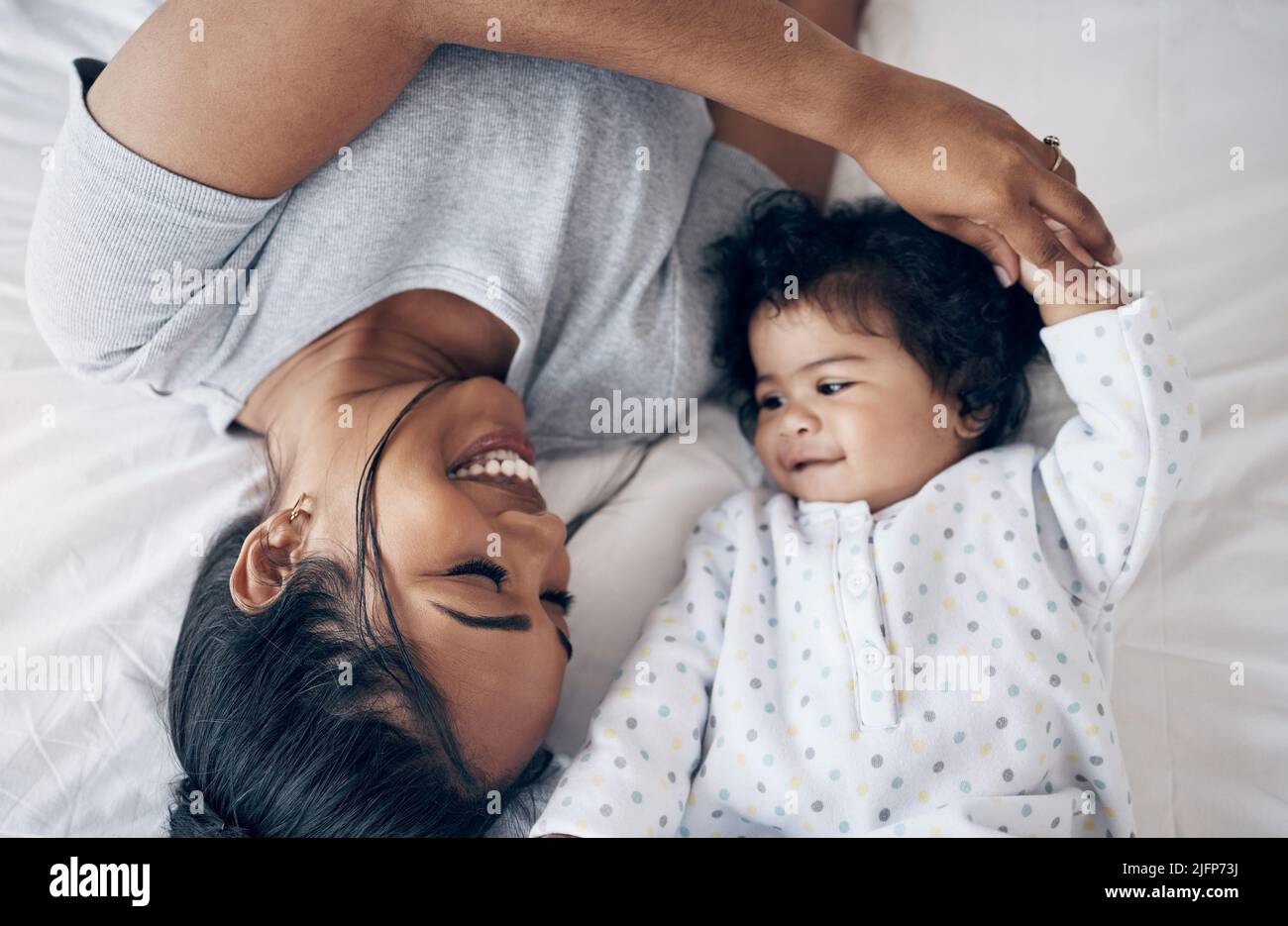 Mom, youre upside down. Shot of a young mother bonding with her baby girl in bed at home. Stock Photo