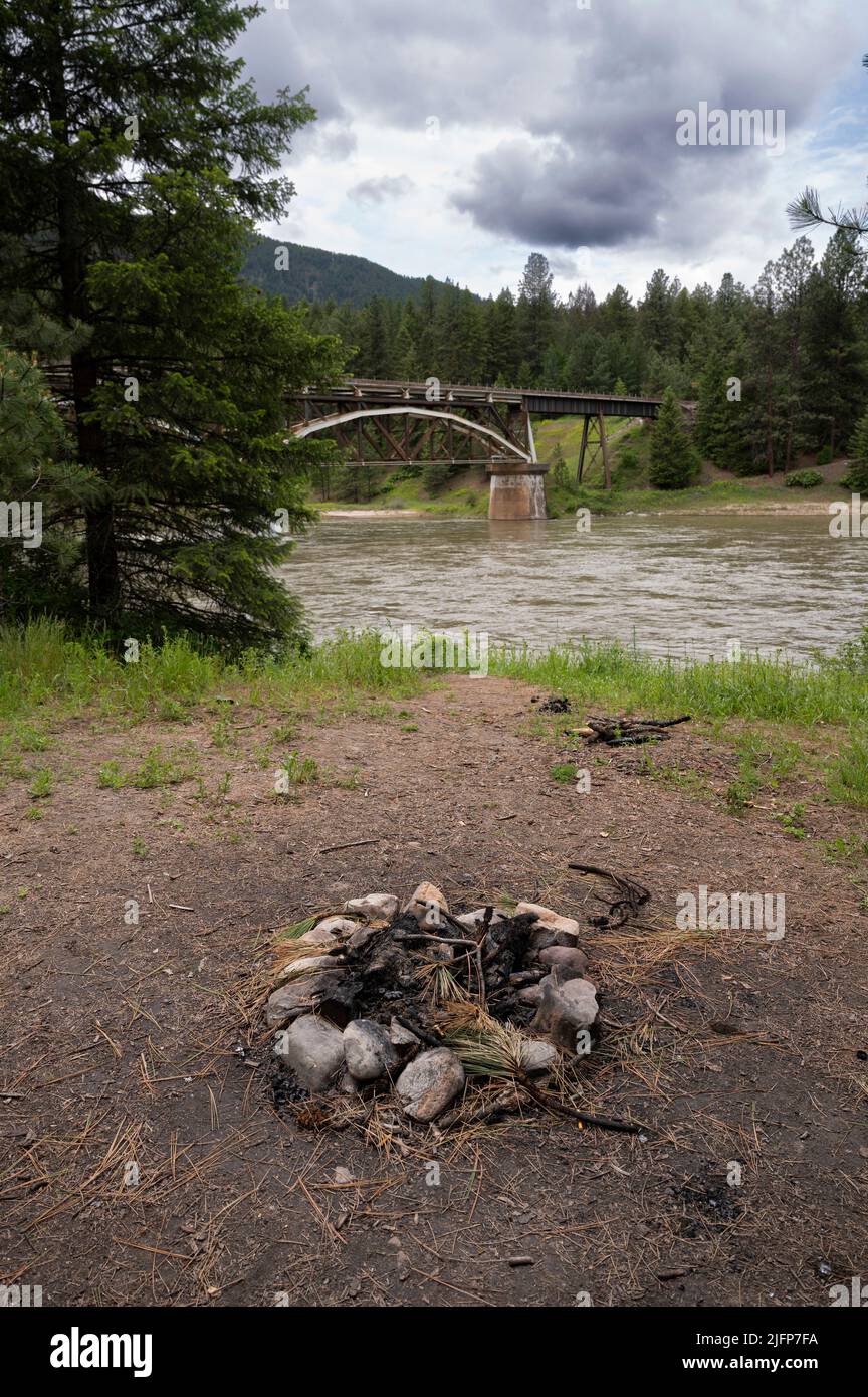 St. Regis, Montana, USA. 20th June, 2022. A campfire pit is seen with a railroad bridge crossing over the Clark Fork River near St. Regis, Montana on June 20, 2022. (Credit Image: © David Becker/ZUMA Press Wire) Stock Photo