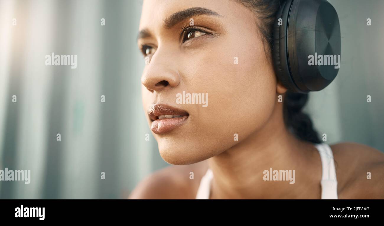 Closeup of one fit young hispanic woman listening to music with ...