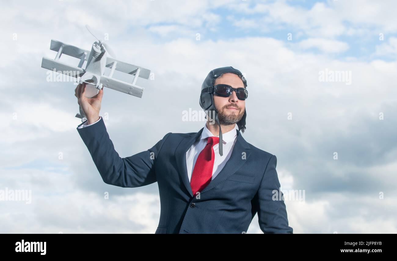 businessman in suit and pilot hat launch plane toy. accomplishment Stock Photo