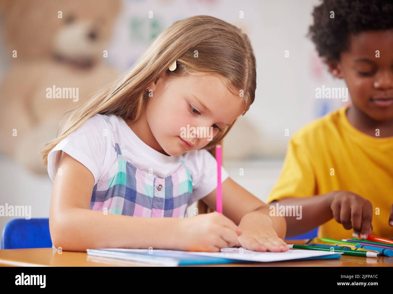 Our days are filled with learning activities. Shot of a preschooler colouring in class. Stock Photo