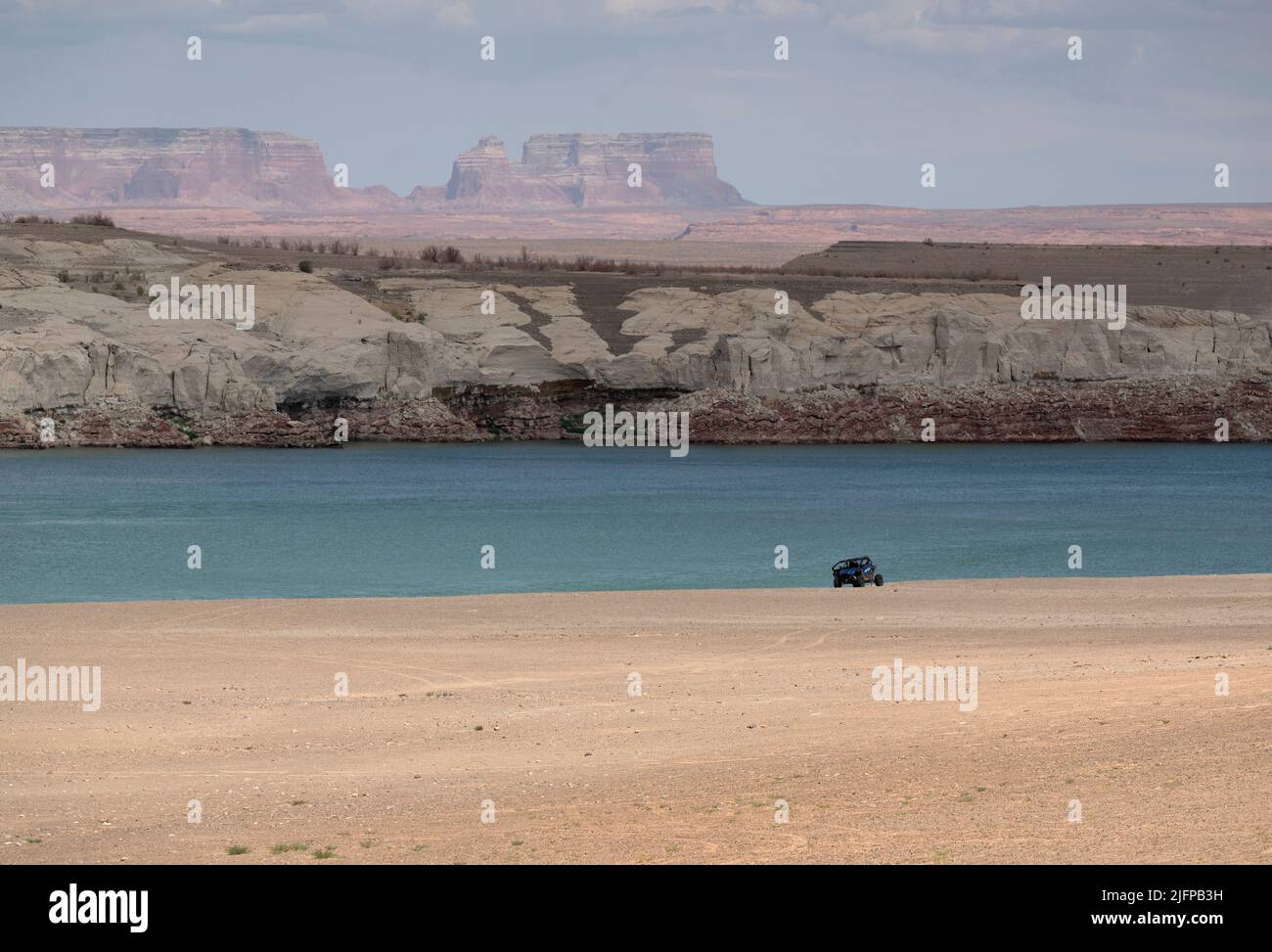 June 30, 2022 - Glen Canyon National Recreation Area, Utah, U.S. - A dune buggy rides on an area of Lake Powell that used to be underwater is now dry at Lone Rock Beach on June 30, 2022 in Big Water, Utah. As severe drought grips parts of the Western United States, water levels at Lake Powell have dropped to their lowest levels since the lake was created by damming the Colorado River in 1963. The Colorado River Basin connects Lake Powell and Lake Mead and supplies water to 40 million people in seven western states. (Credit Image: © David Becker/ZUMA Press Wire) Stock Photo