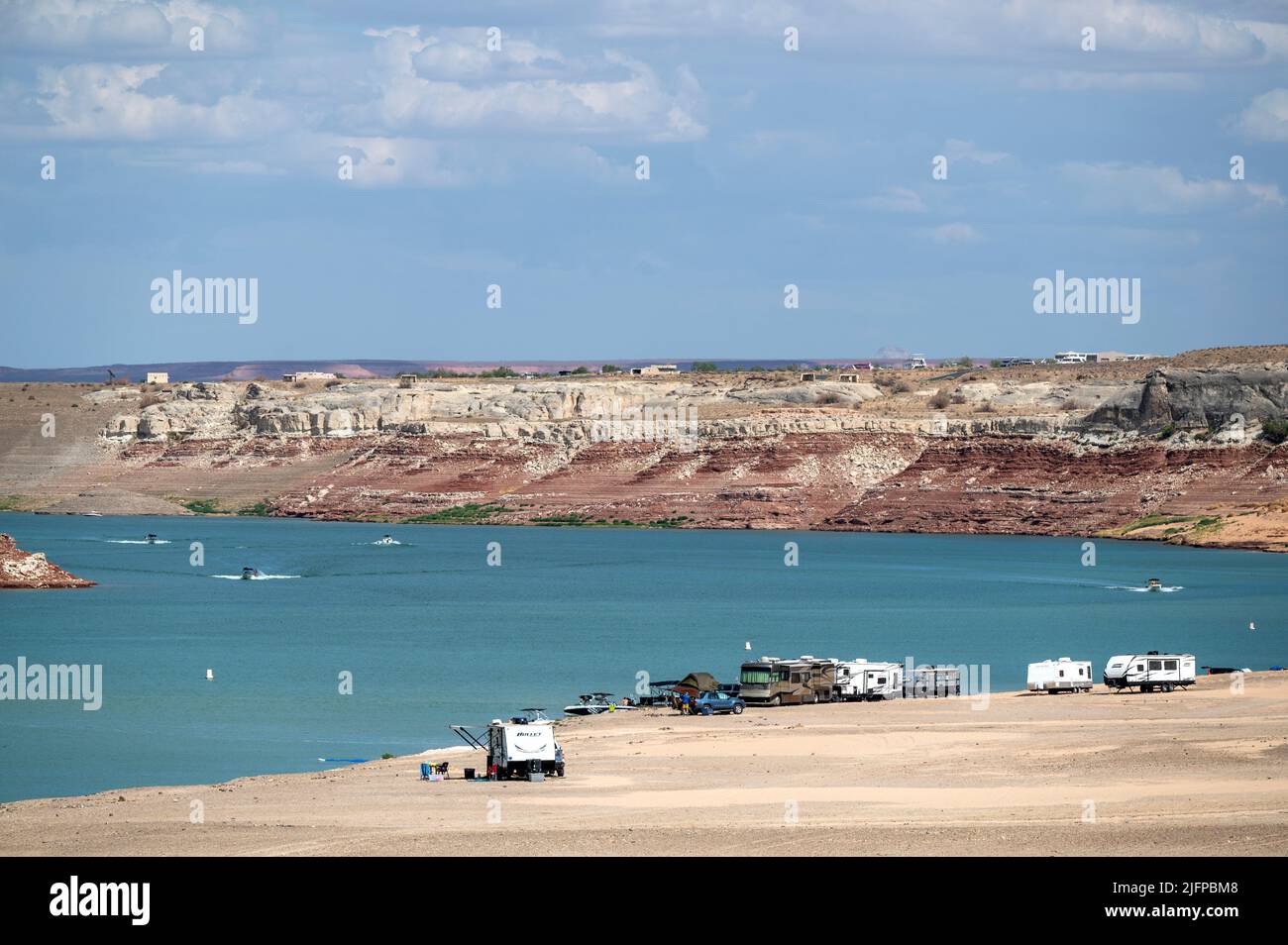 June 30, 2022 - Glen Canyon National Recreation Area, Utah, U.S. - People camp at an area of Lake Powell that used to be underwater is now dry at Lone Rock Beach on June 30, 2022 in Big Water, Utah. As severe drought grips parts of the Western United States, water levels at Lake Powell have dropped to their lowest levels since the lake was created by damming the Colorado River in 1963. The Colorado River Basin connects Lake Powell and Lake Mead and supplies water to 40 million people in seven western states. (Credit Image: © David Becker/ZUMA Press Wire) Stock Photo