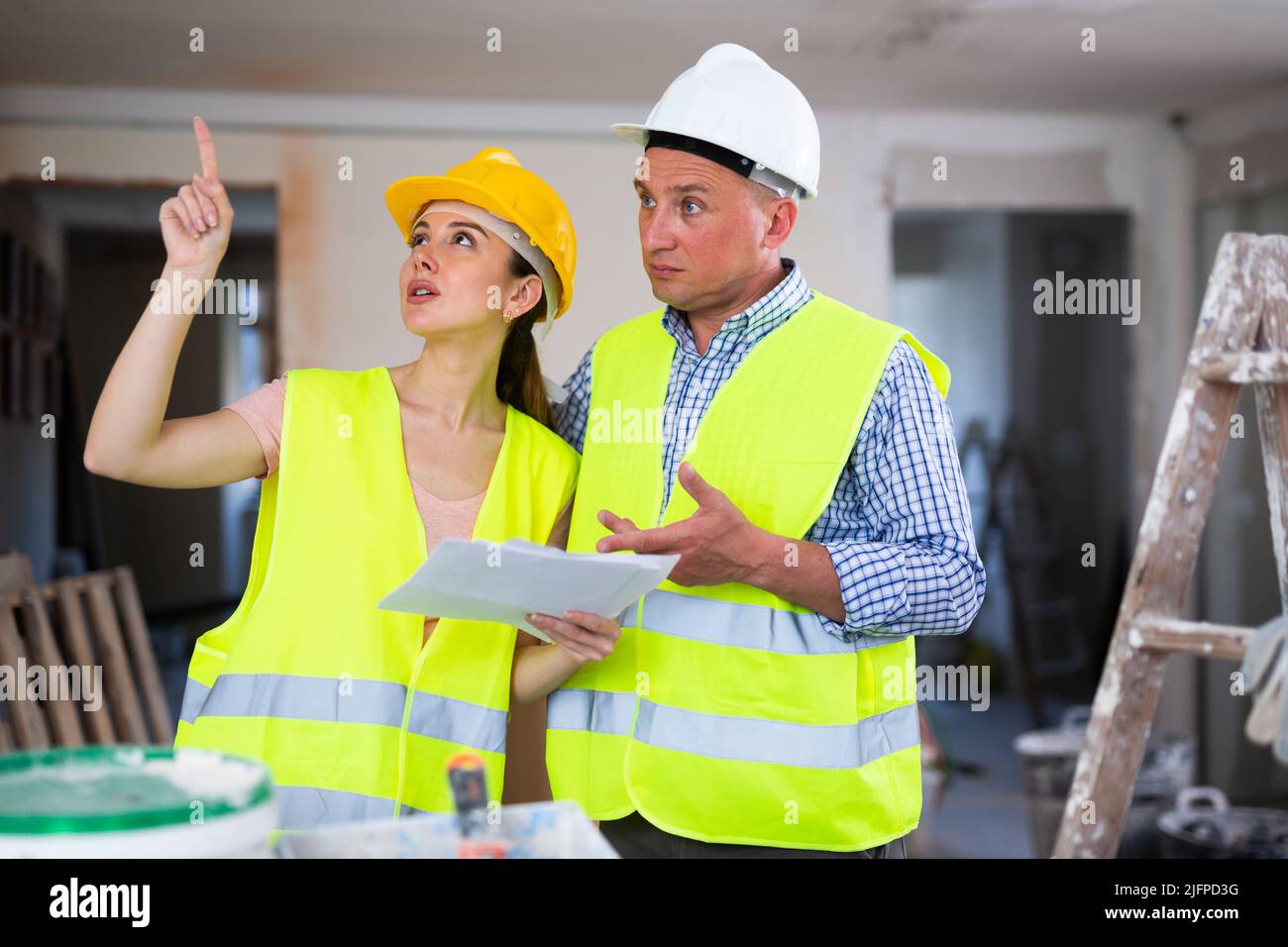 Woman and man repairers talking about documentation Stock Photo