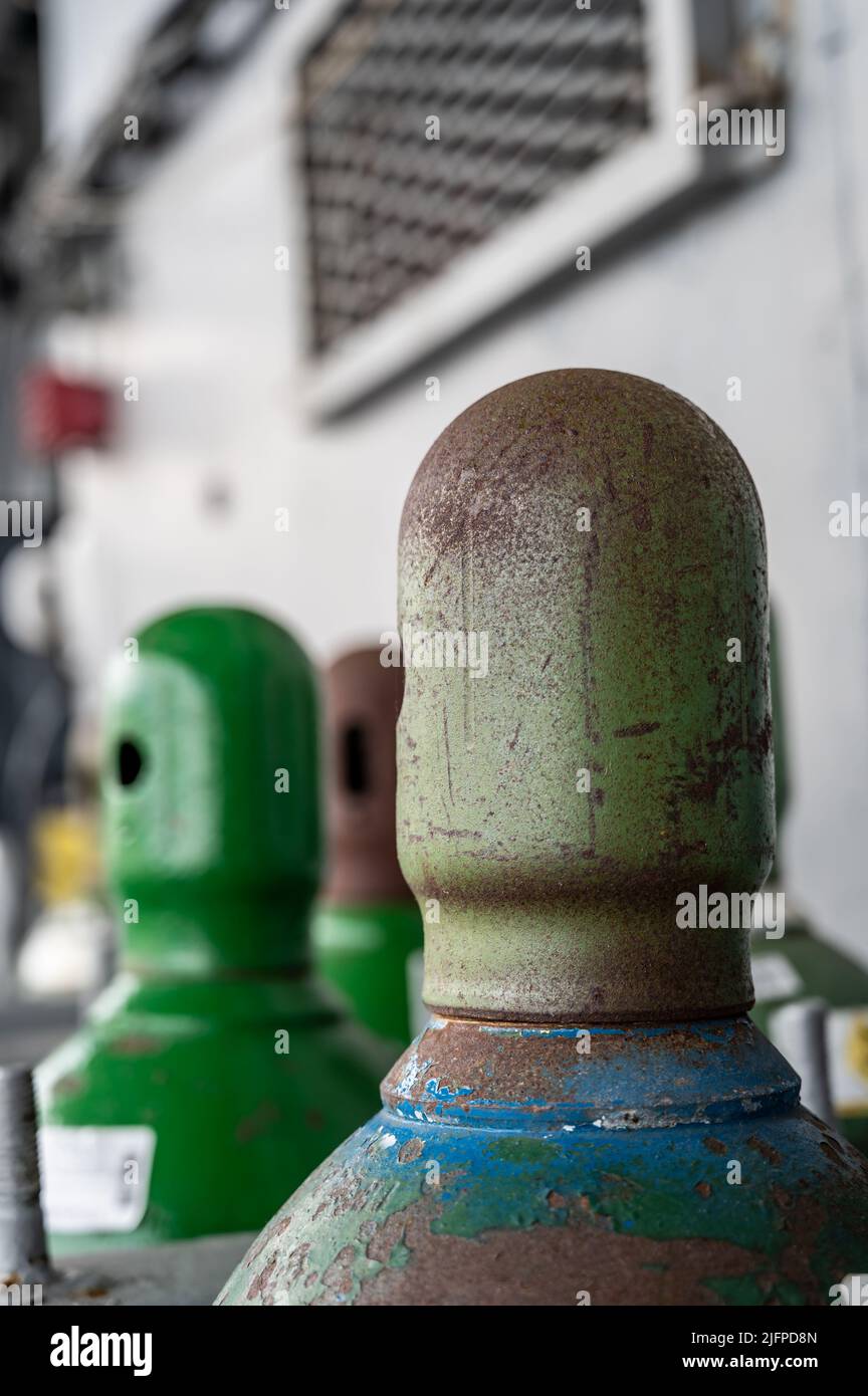 Compressed gas cylinders being stored vertically secured by a metal
