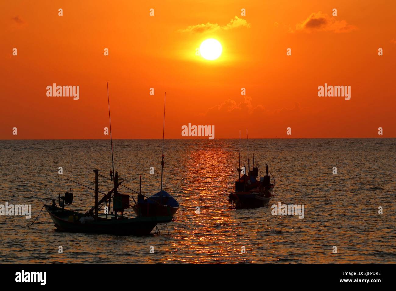 fishing boat in the sea with beautiful sunset background Stock Photo