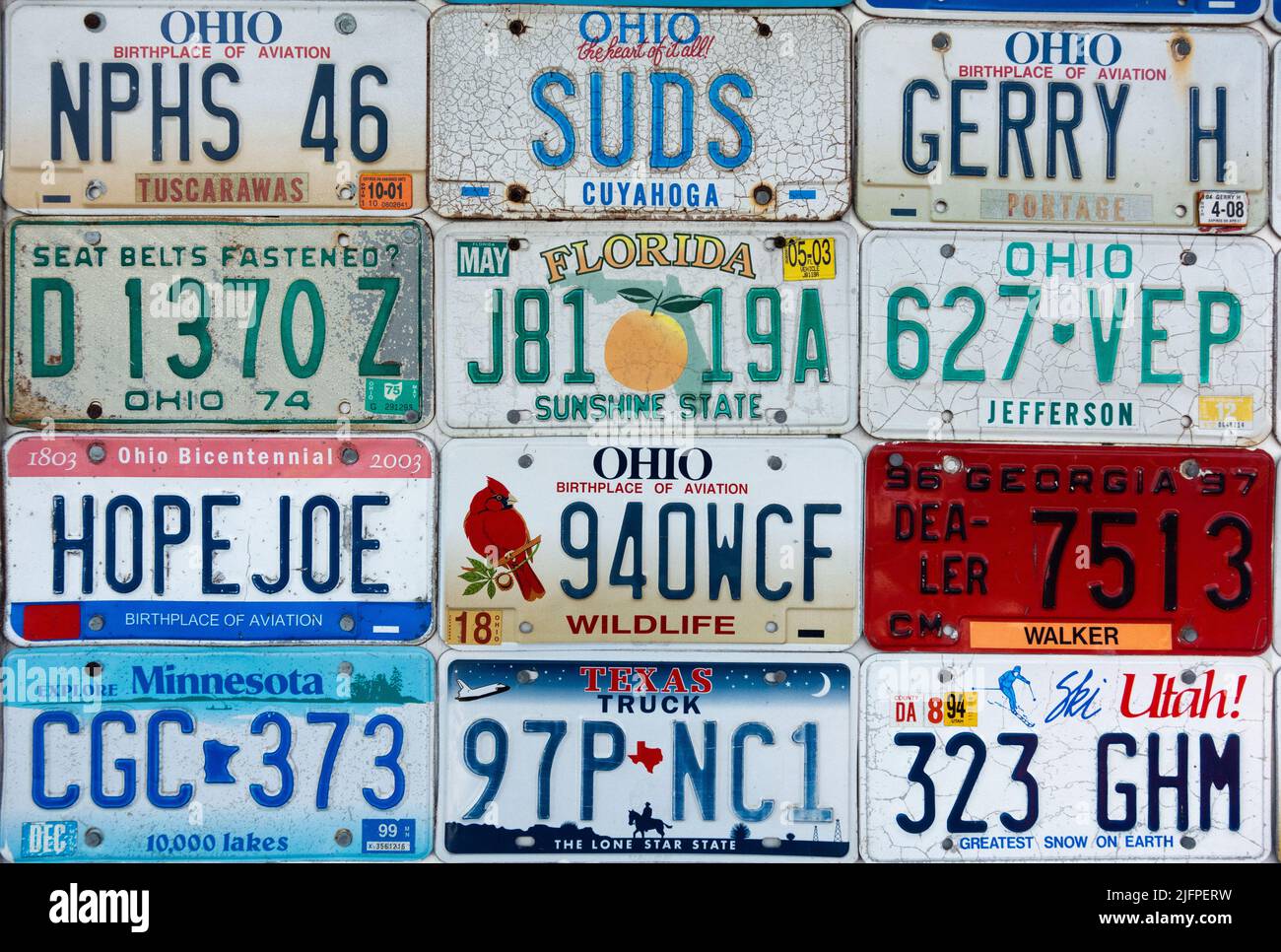 Various United States automobile license plates hung in rows on a wall Stock Photo
