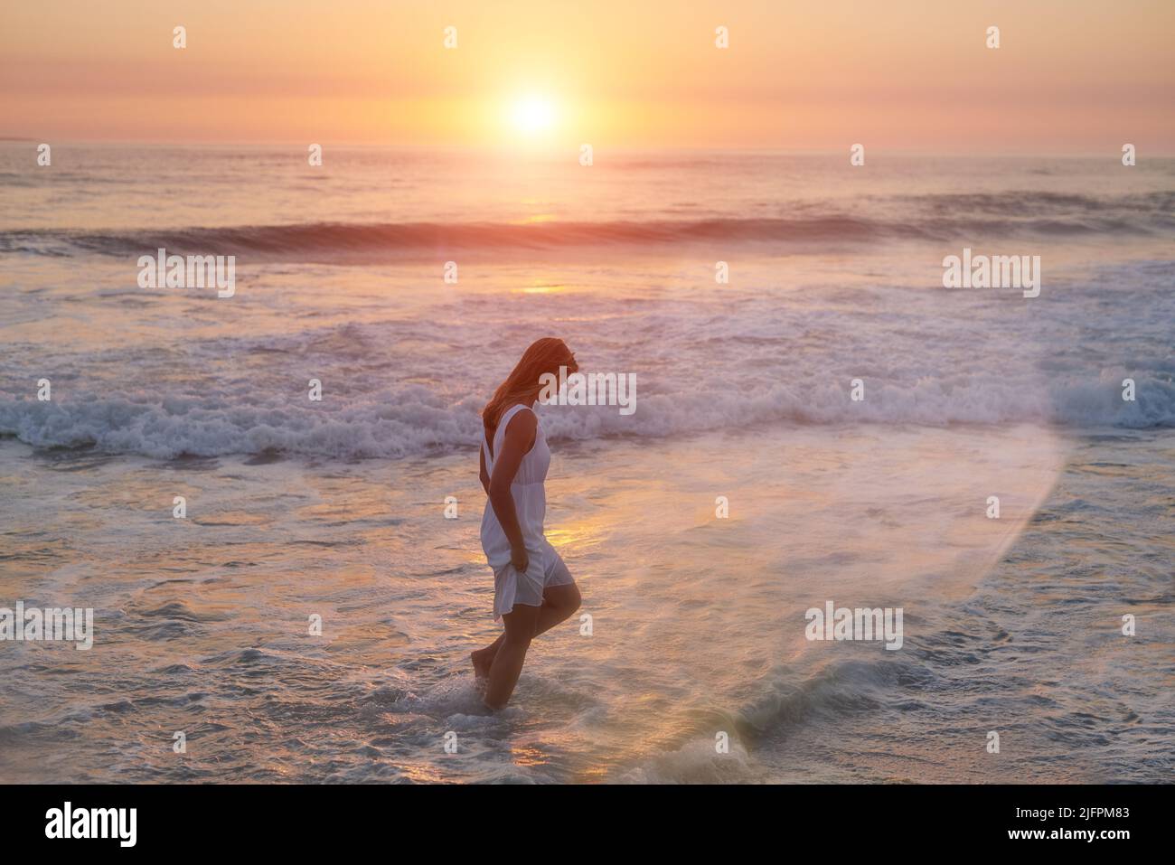 Good times and tan lines. Shot of a young woman walking along the beach. Stock Photo