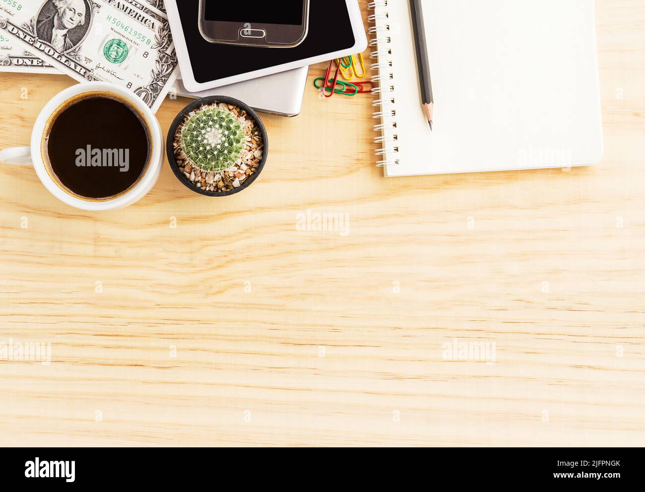 Vintage office desk with notebooks,cactus,smart phone and a cup of