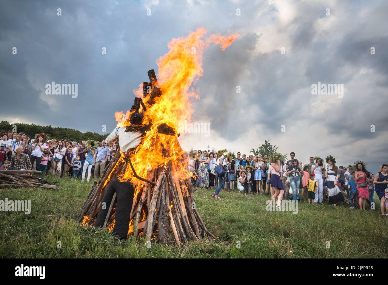 Bonfire and spectators are seen during the ritual test of bravery and faith. This holiday symbolizes the birth of the summer sun – Kupalo. The history of the Christian Church can answer us how the pagan deity Kupalo gets the name of Ivan. In the IV century AD, this day was proclaimed the holiday of the birth of John the Baptist - the forerunner of Jesus Christ. As a result of the Christianization of the pagan feast the name 'Kupala' got connected with the Christian 'Ivan'. On the territory of Ukraine for many centuries Kupala customs changed, there were always local differences, and they were Stock Photo