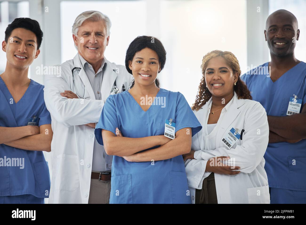 Merging their expertise and skills to overcome complex cases. Portrait of a group of medical practitioners standing together with their arms crossed Stock Photo