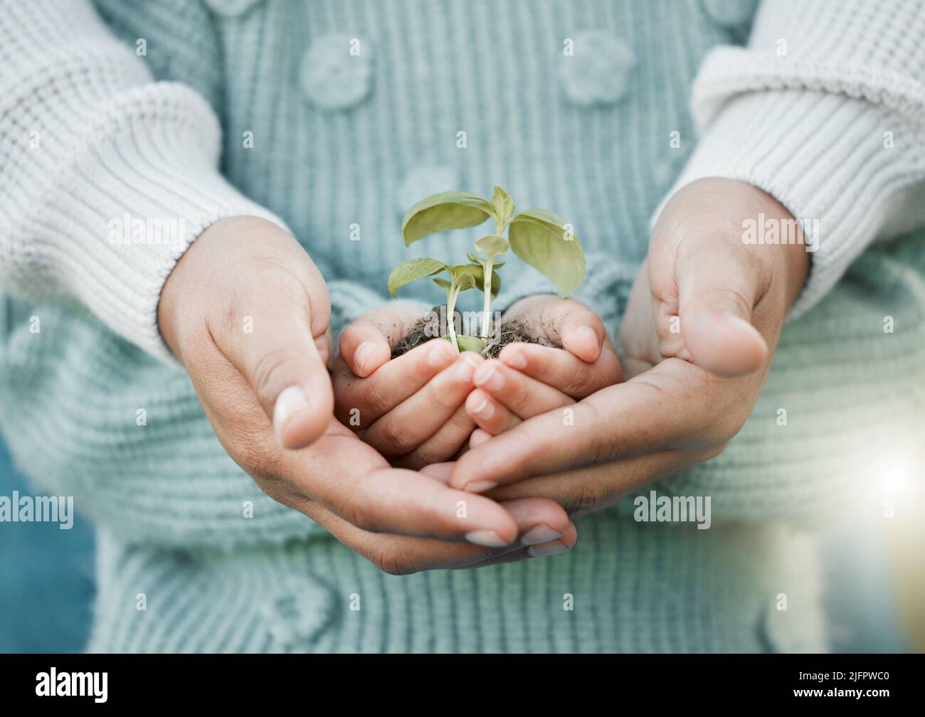 You are my family because I love you. Shot of a unrecognizable man and a little girl holding a plant outside. Stock Photo