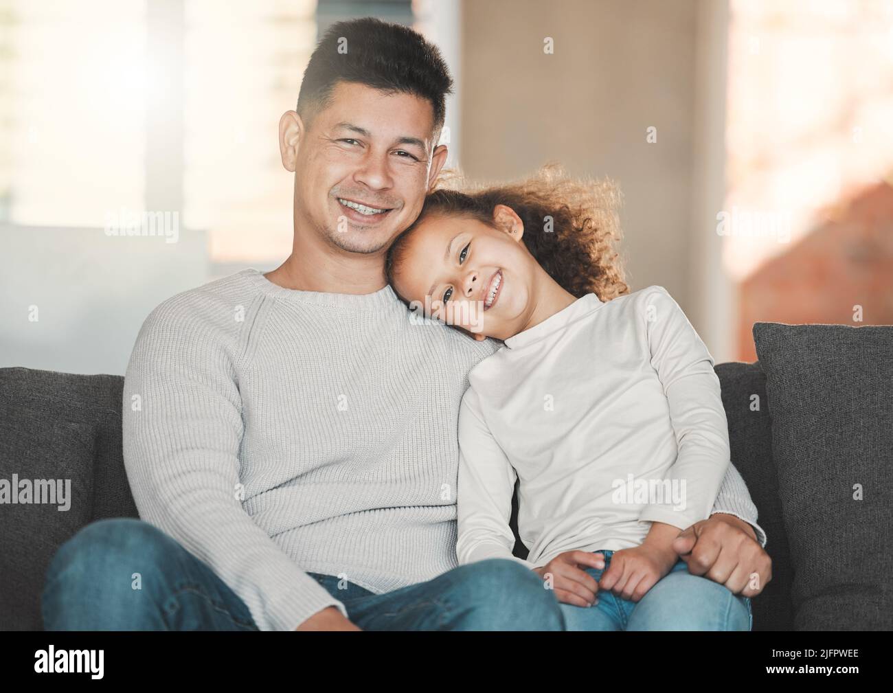 We are family. Shot of a father and daughter on the sofa at home. Stock Photo