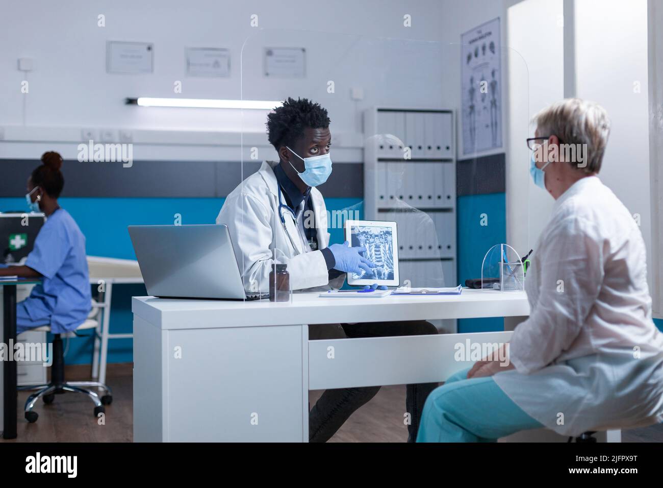 Clinic radiologist showing radiogram to sick elderly patient and recommending medical procedure. Hospital radiology expert specialist informing ill senior woman of bad bone system condition. Stock Photo