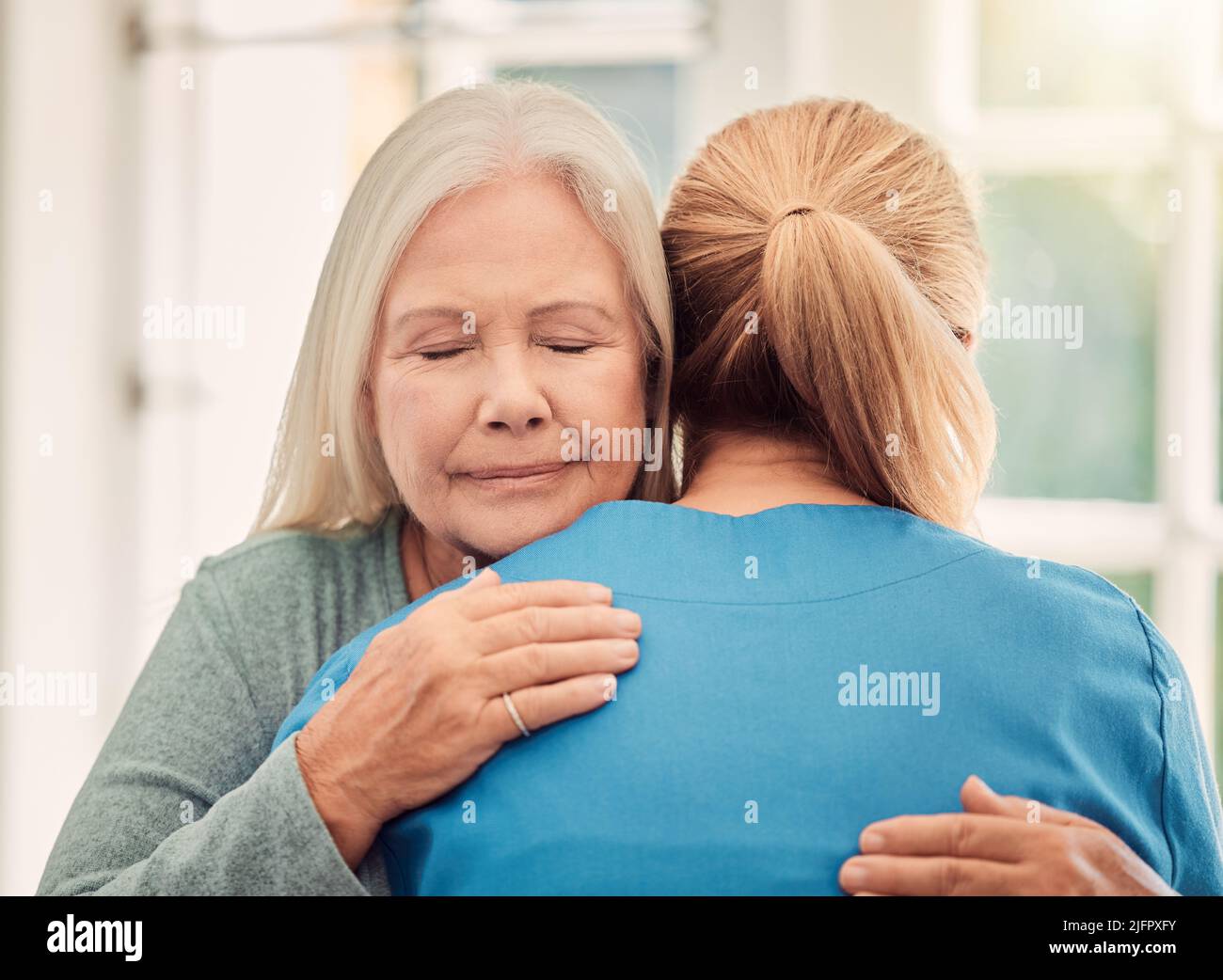 Empathy is a connection. Shot of a nurse hugging to her female patient at home. Stock Photo