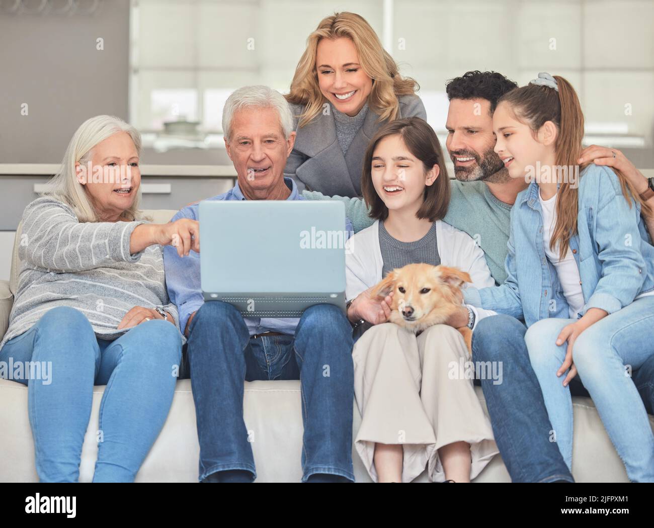 Family planning. Shot of a family using a laptop while sitting on a sofa together at home. Stock Photo