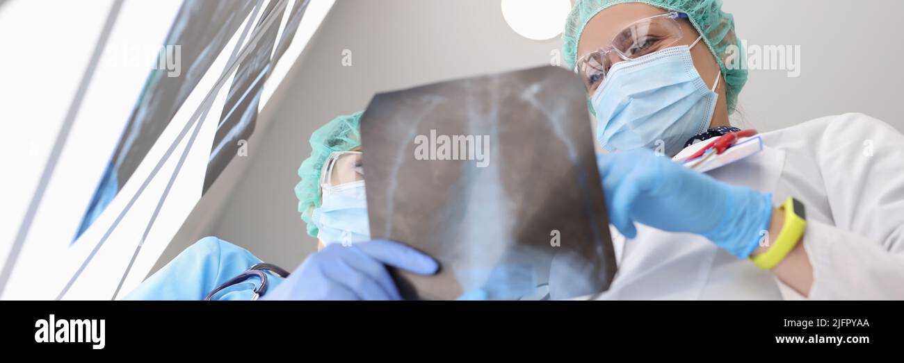 Medical workers examine x ray of patient lungs, colleagues discuss scan result Stock Photo