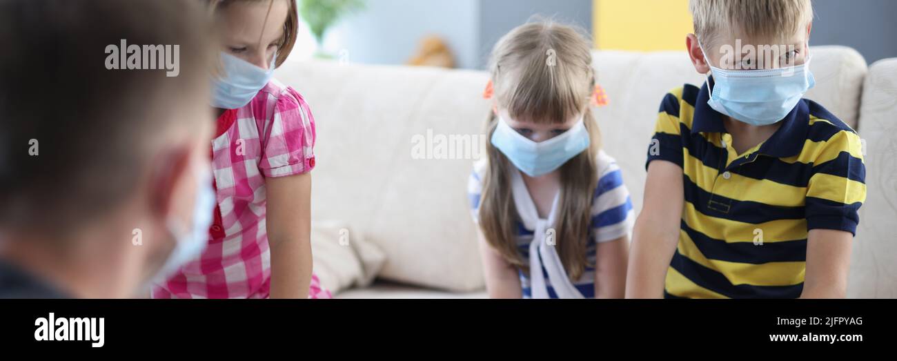 Children wearing face mask, virus spread in kindergarten, friends got sick Stock Photo