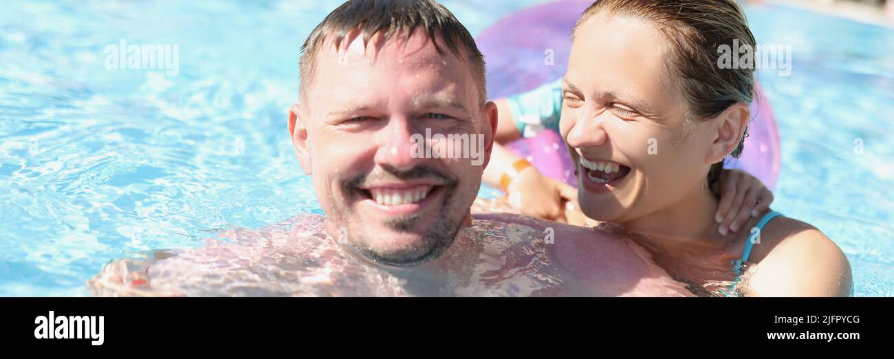 Cheerful couple posing for picture in swimming pool in luxury resort Stock Photo