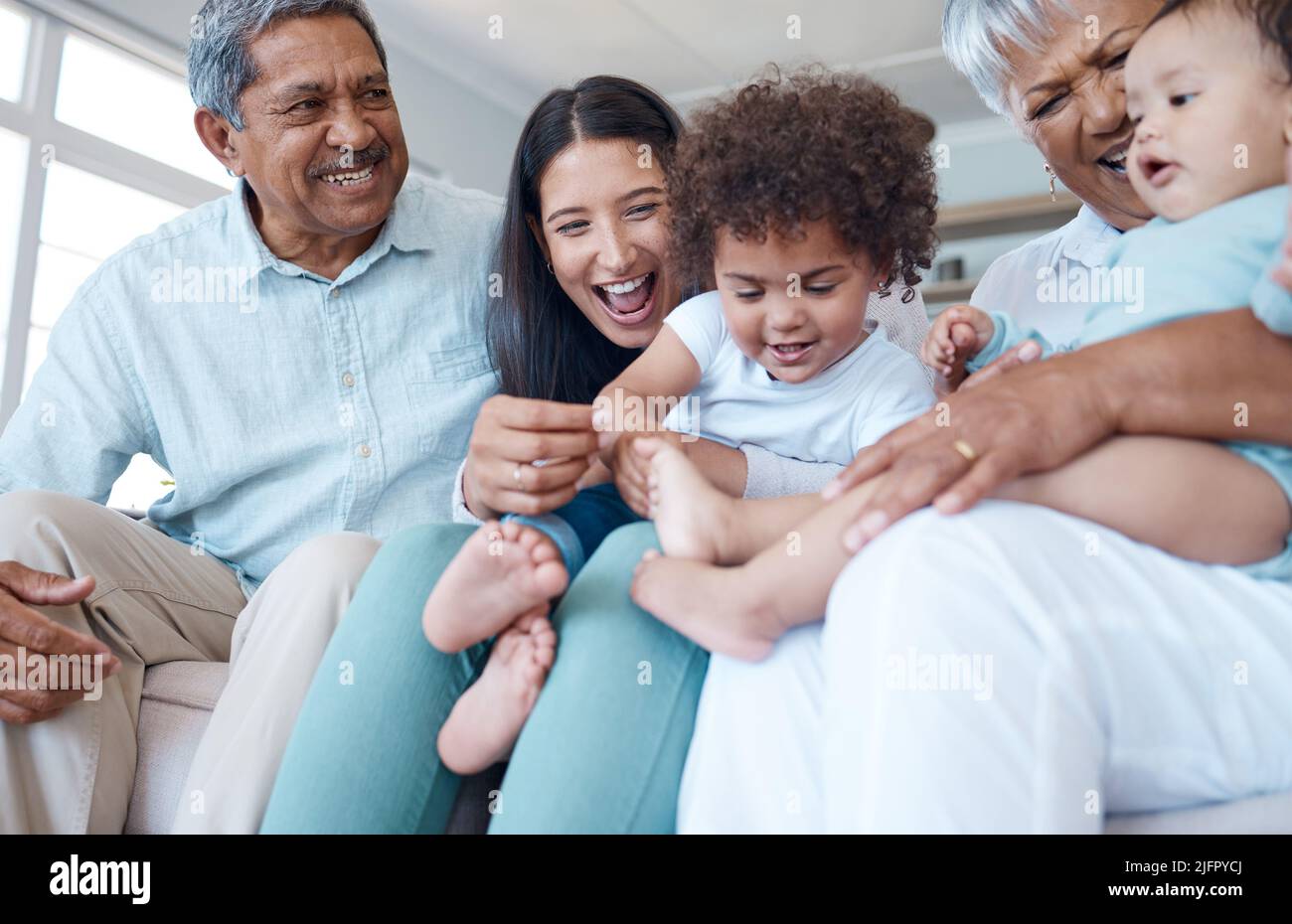 Always loved here. Shot of a beautiful family bonding on a sofa at home. Stock Photo
