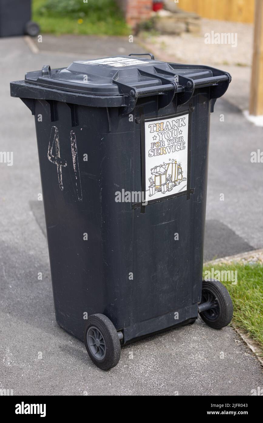 Plastic garbage wheelie bin on the street with a sticker in support of