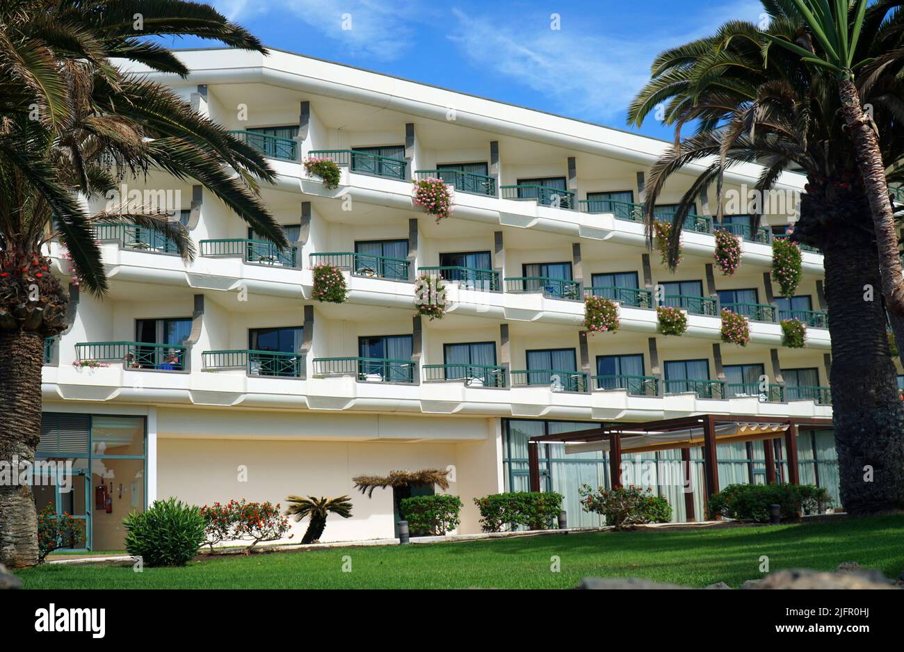 Hotel balconies and palm trees on a sunny day. Stock Photo