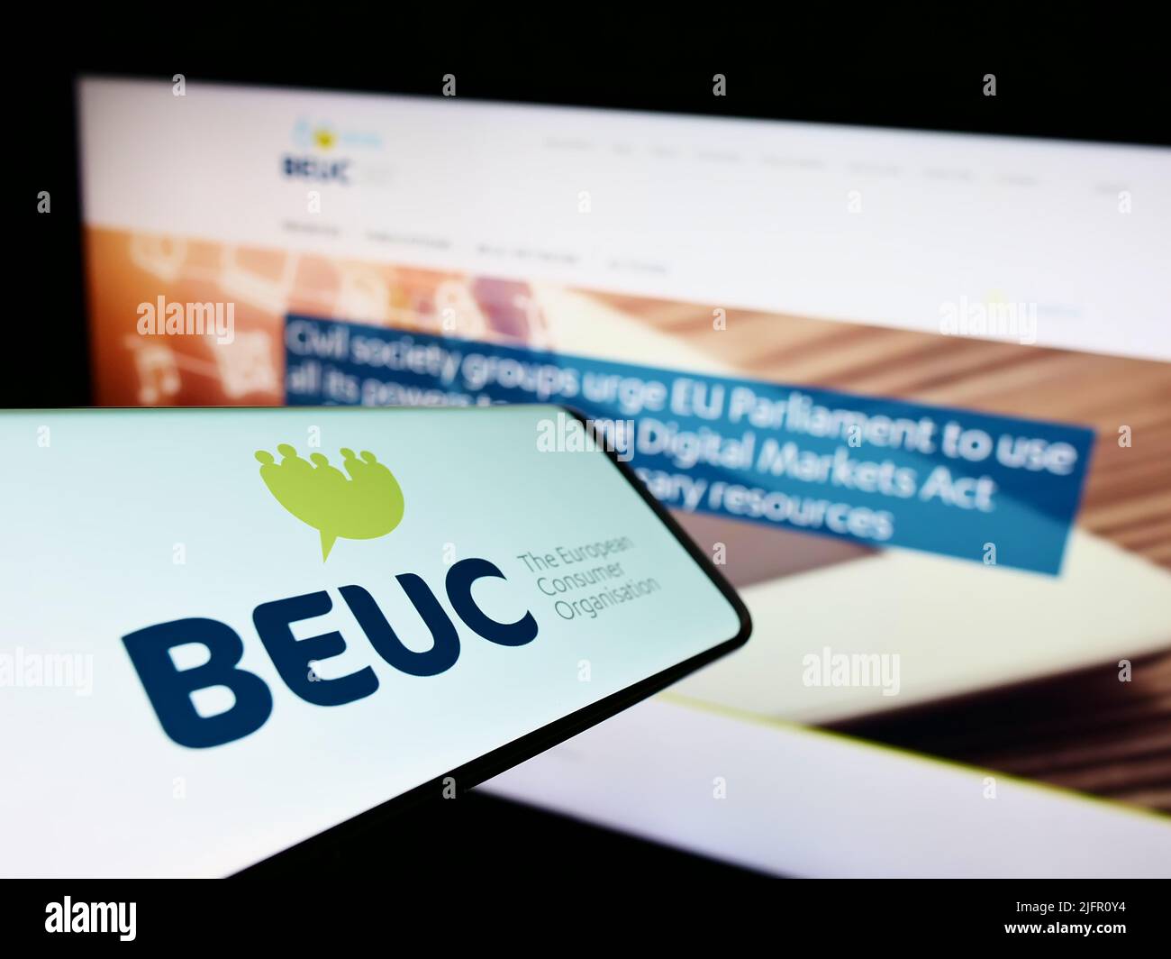 Smartphone with logo of Bureau Europeen des Unions de Consommateurs (BEUC) on screen in front of website. Focus on center-right of phone display. Stock Photo