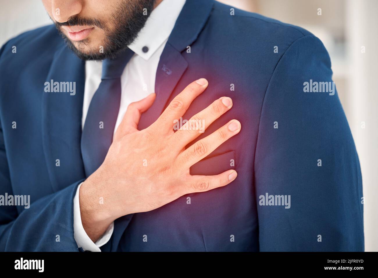 What could this pain be. Shot of an unrecognizable businessperson suffering from chest pain at work. Stock Photo