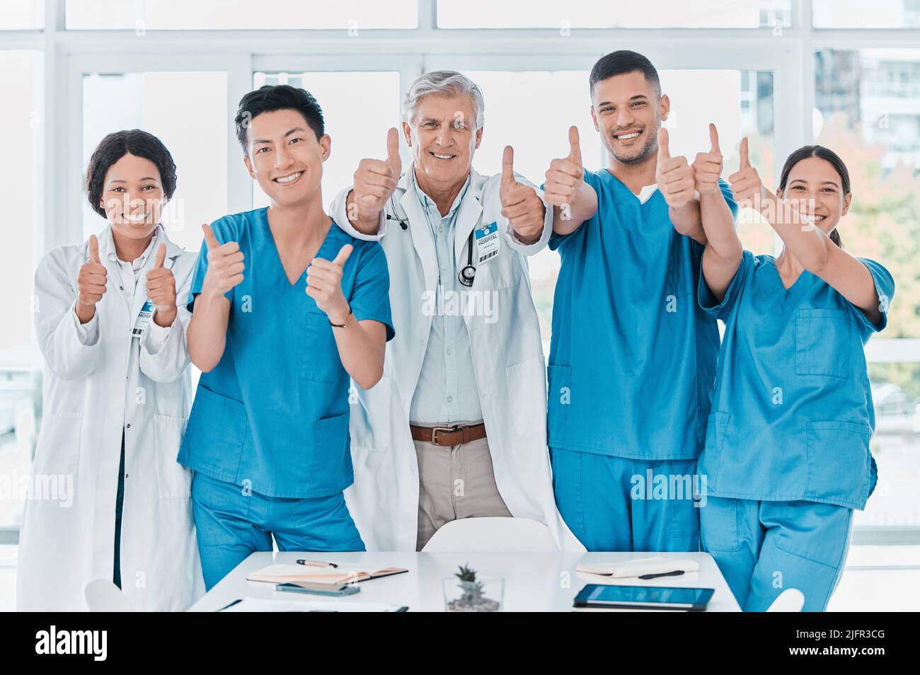 As confident as they are capable. Portrait of a group of medical practitioners showing thumbs up together in a medical office. Stock Photo
