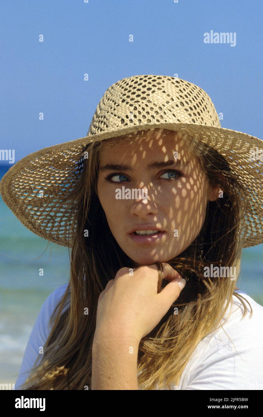 Pretty young woman looking front camerasea water backgrond blond hair good looking with straw hat very healthy Stock Photo