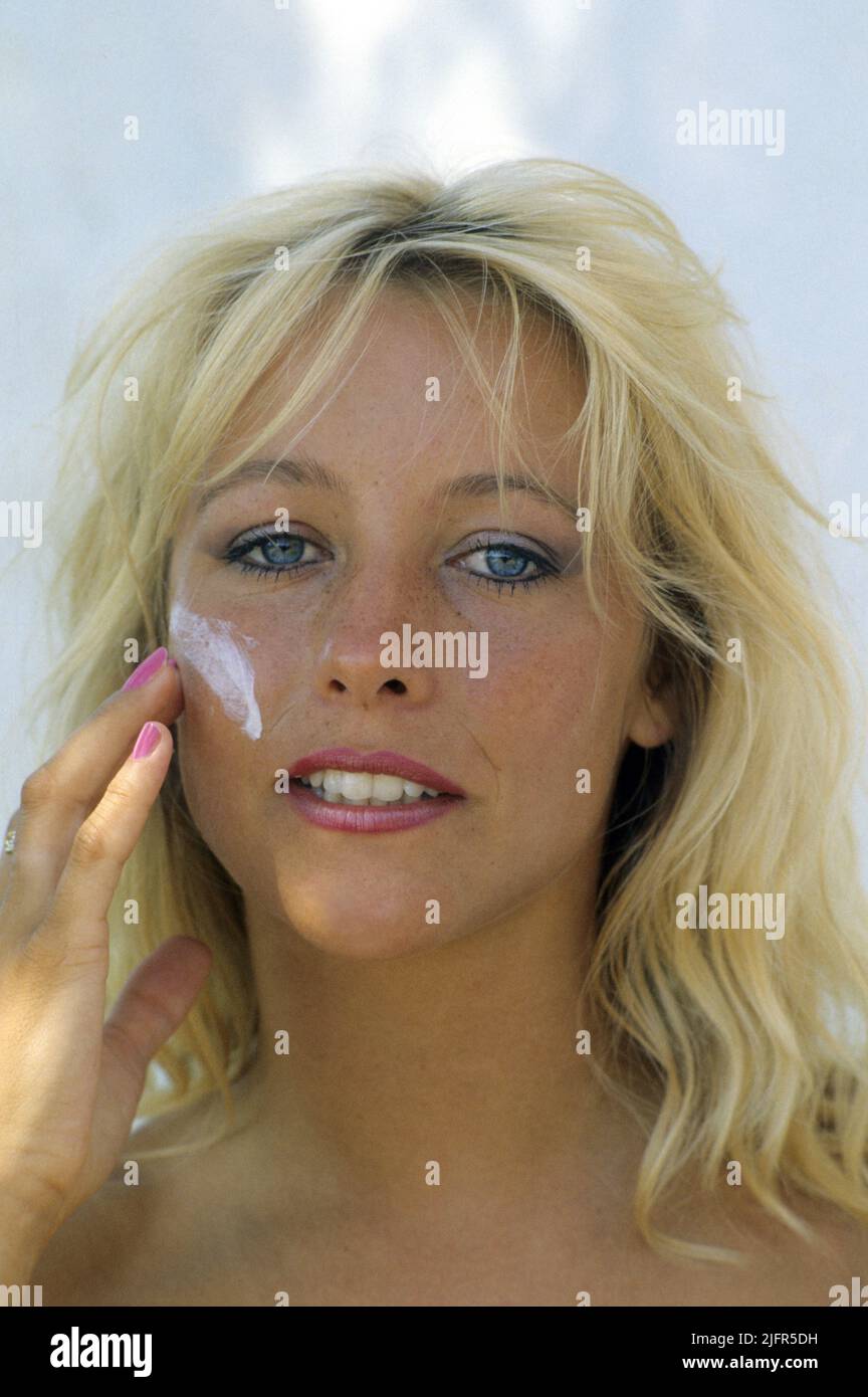pretty blond hair young woman skin care sunscreen cream front camera Stock Photo
