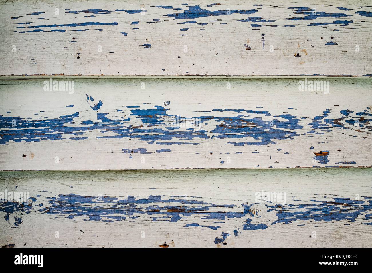 Old wood texture with horizontal boards, peeling white paint on light blue background. Old wooden planks. Abstract surface. Rustic texture of wood. Ho Stock Photo