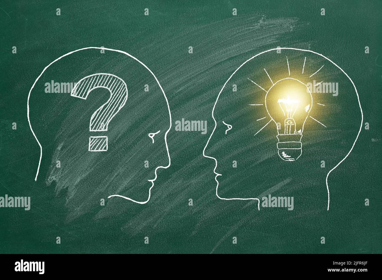 Chalk illustration on greenboard. Two male heads face to face with question mark inside and one head with light bulb inside. Answer to question. Debat Stock Photo