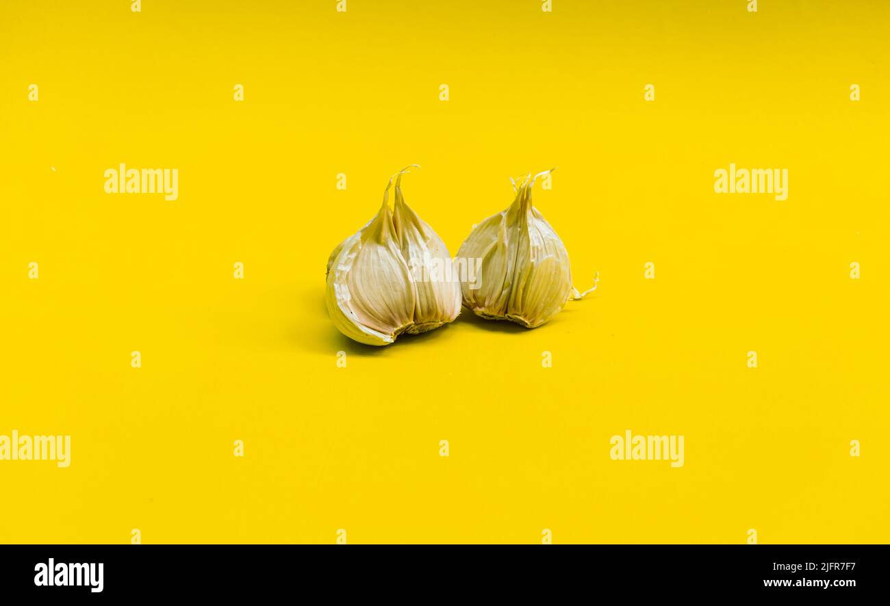 a few cloves of garlic on a yellow background isolated Stock Photo Alamy