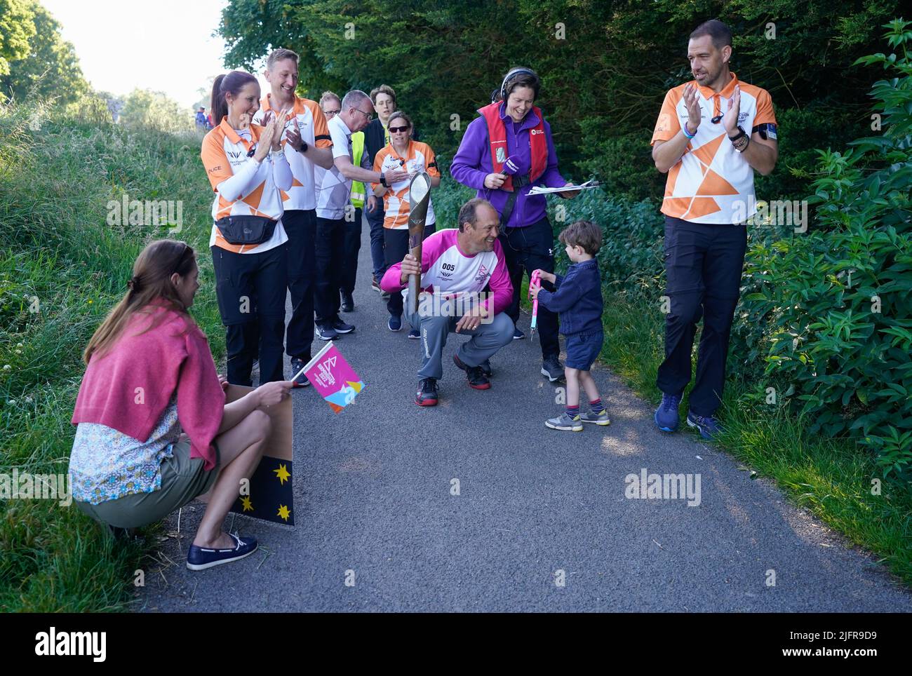 Baton bearer Julian StaffordWood is given a medal by his some Theodore