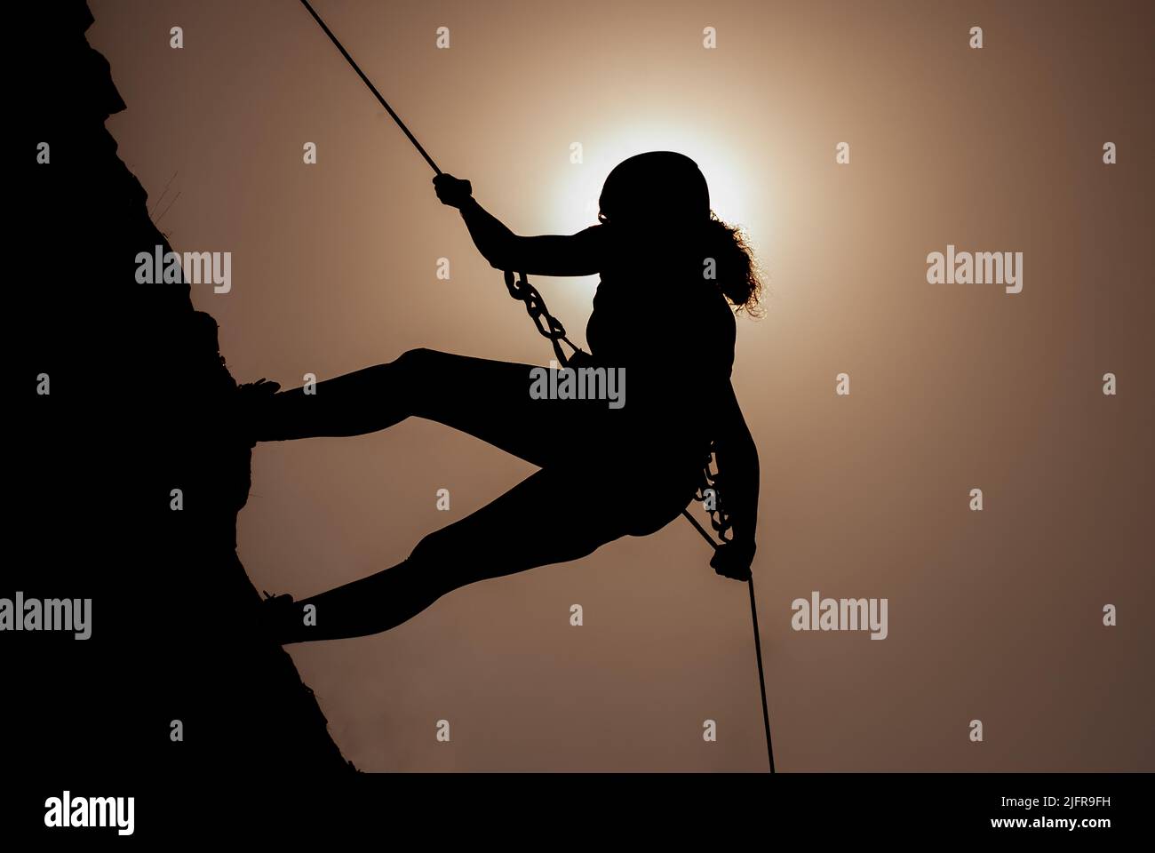 Silhouette of successful young female climber in the mountains Concept of self-improvement, motivation, movement inspiration, motivational goals. Adve Stock Photo