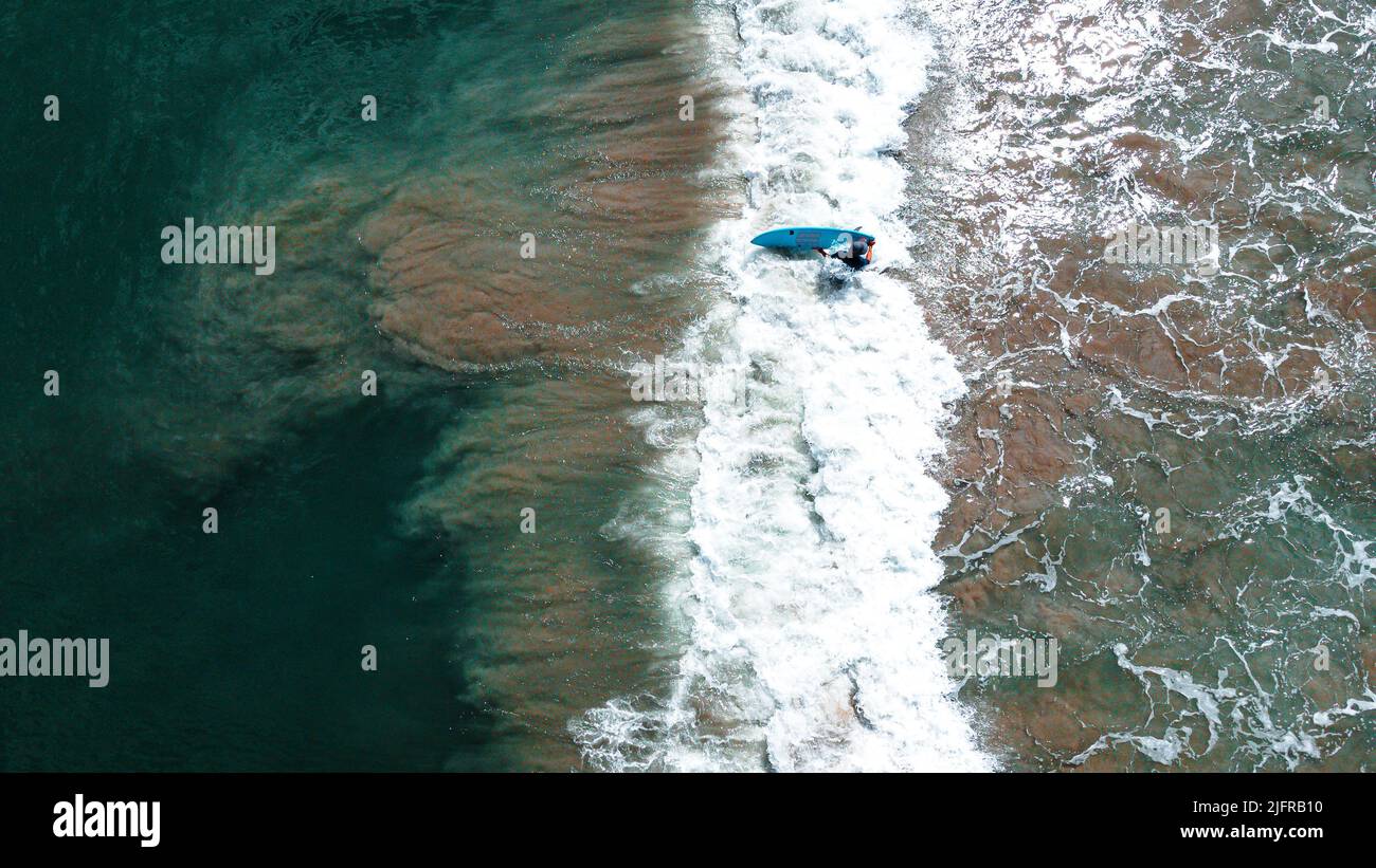 A top view of a surfer surfing the waves in Tamarin Bay, Mauritius