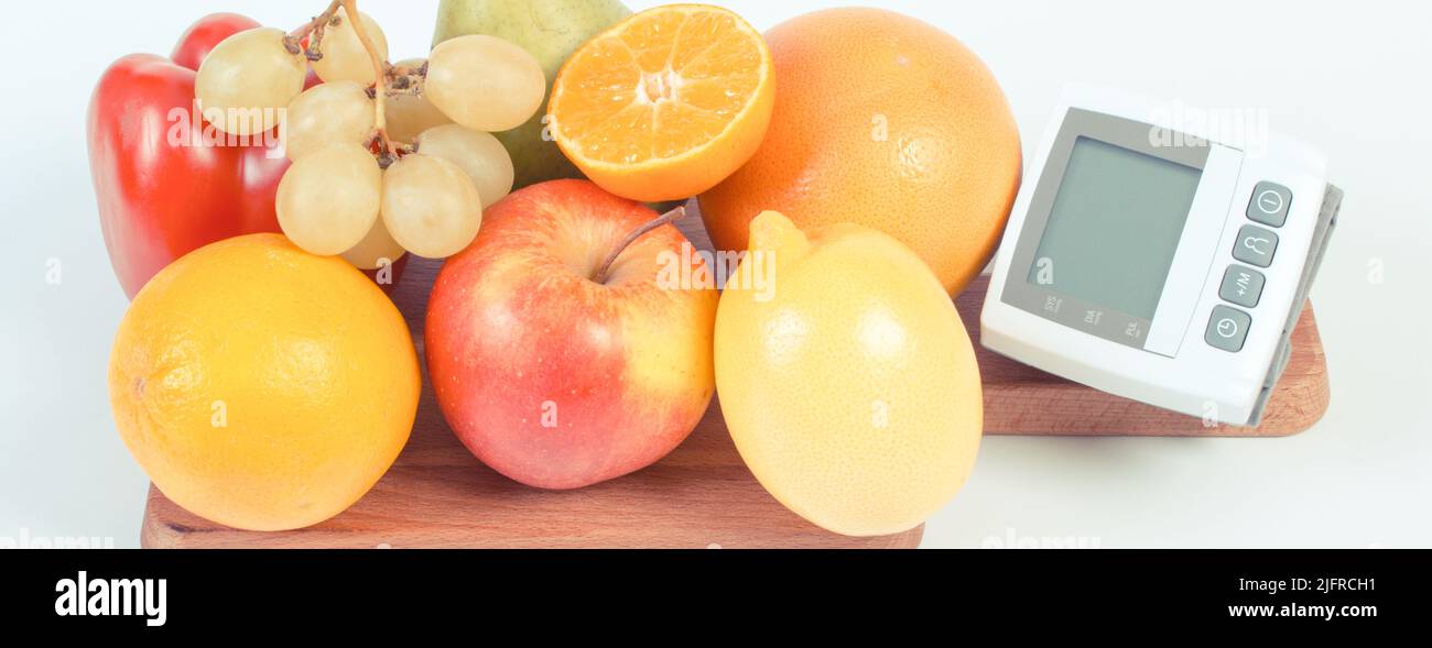 Vintage photo, Blood pressure monitor and fresh fruits with vegetables ...