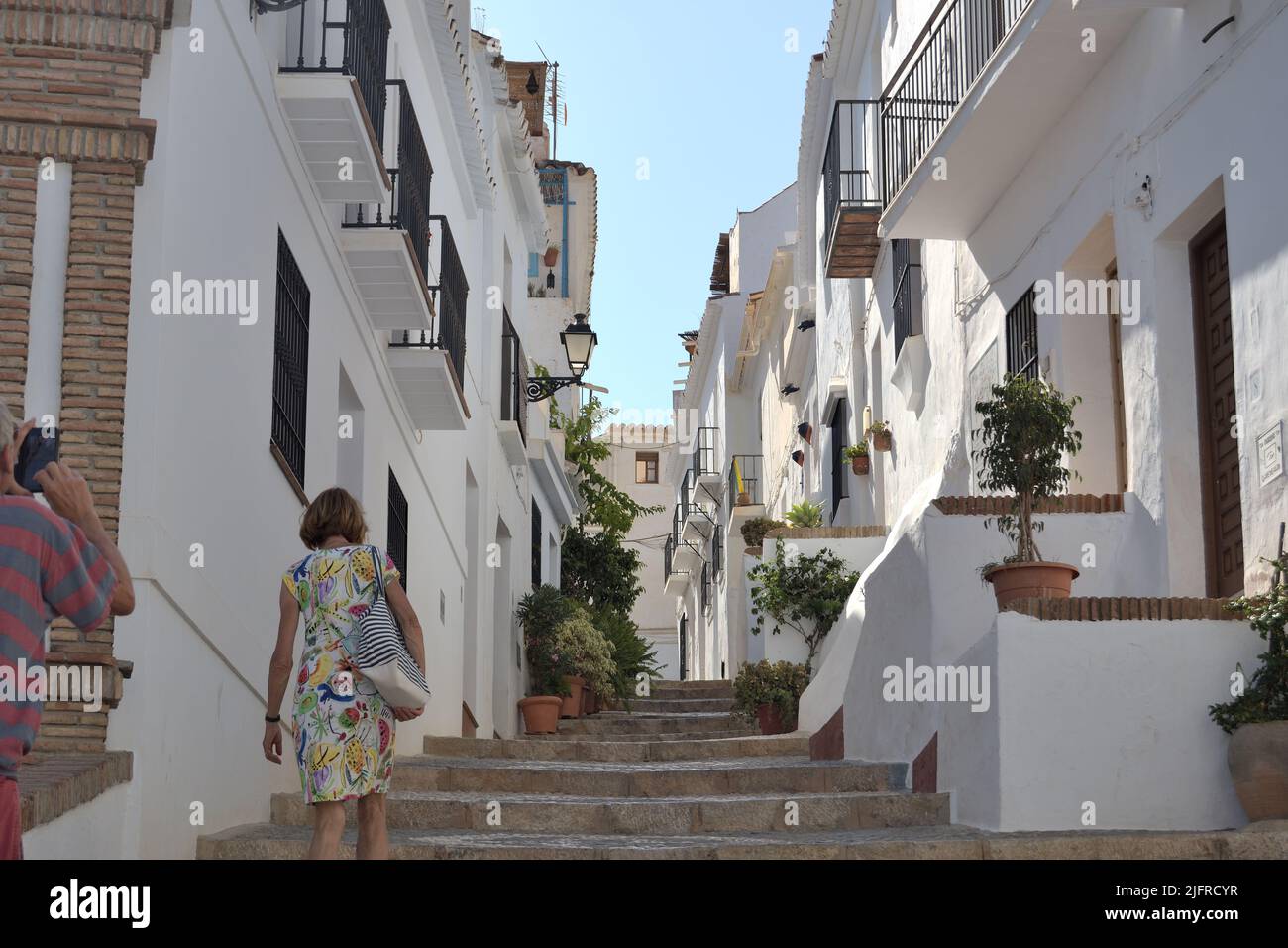 Tourists in a typical whitewashed andalusian street, Frigiliana, Spain