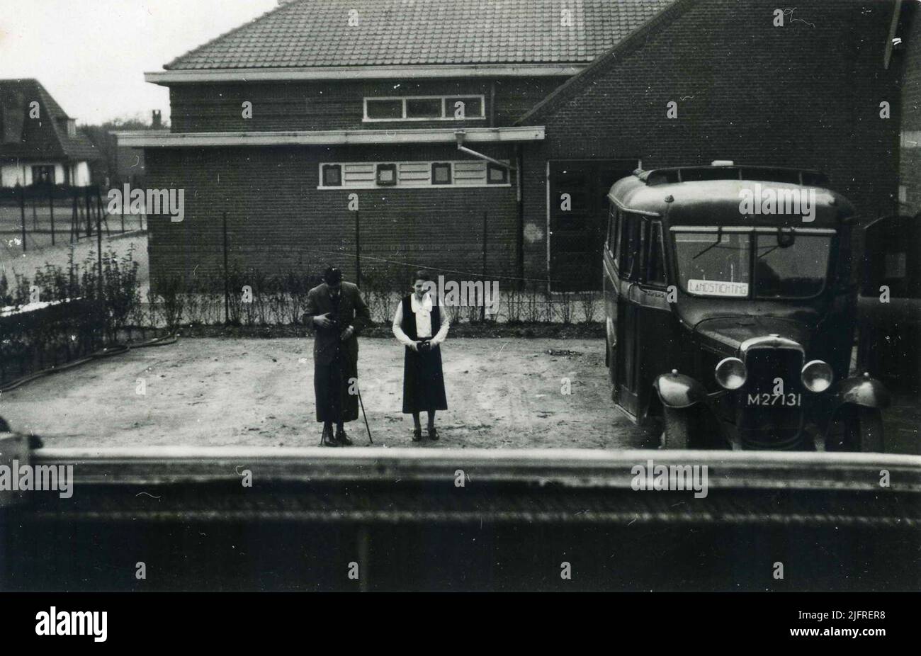 Back of the grocery store and garage of autobus service and taxi company 'Brakkenstein' from entrepreneur/operator Rudolf (Rudolph) Groos (10/08/1881 - 21/11/1944) with one of the buses for passenger transport on the route (Hatert) - Brakkenstein-saint National Foundation-Nijmegen and, in the middle, son Wim and daughter Truus. In the background the Father Eijmardschool, left behind Villa 'Mariahof' '. As of April 1, 1938, the concession and operation of the bus service, started in 1924, were taken over by the Maas-Buurtspoorweg Maatschappij (MBS) Stock Photo