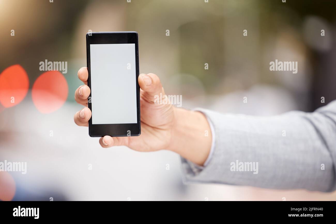 Have you heard. Shot of an unrecognizable businessperson holding a phone in the city. Stock Photo